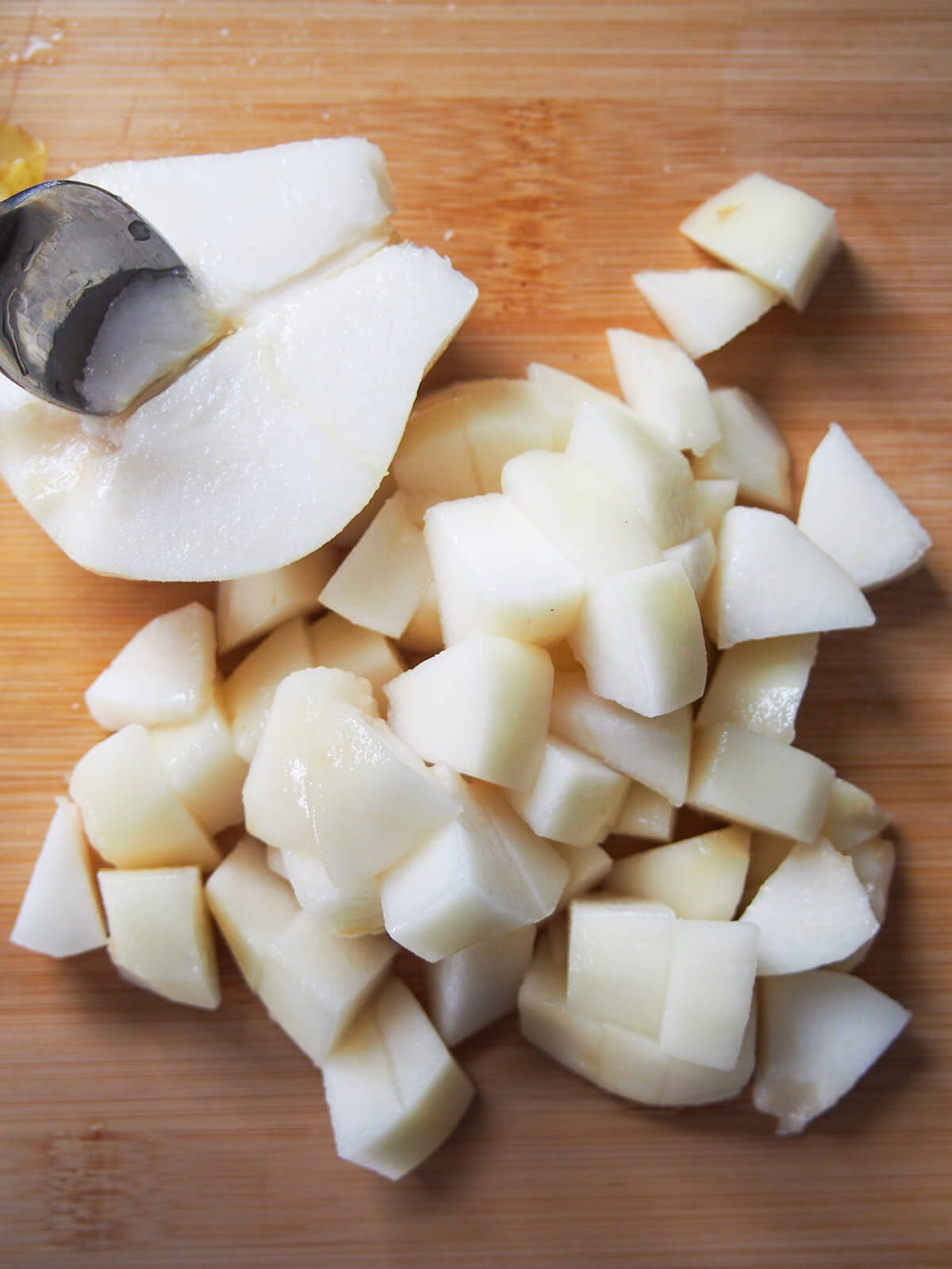 scooping core from pear and diced pear in front