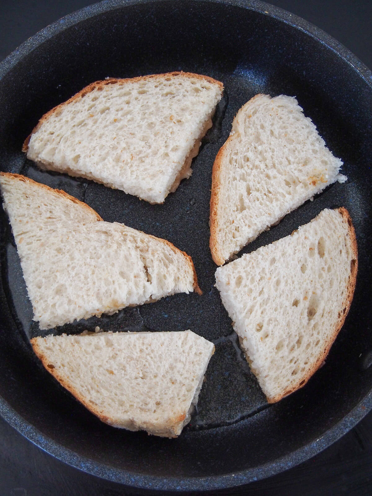 cooking shrimp side down with bread side up in skillet