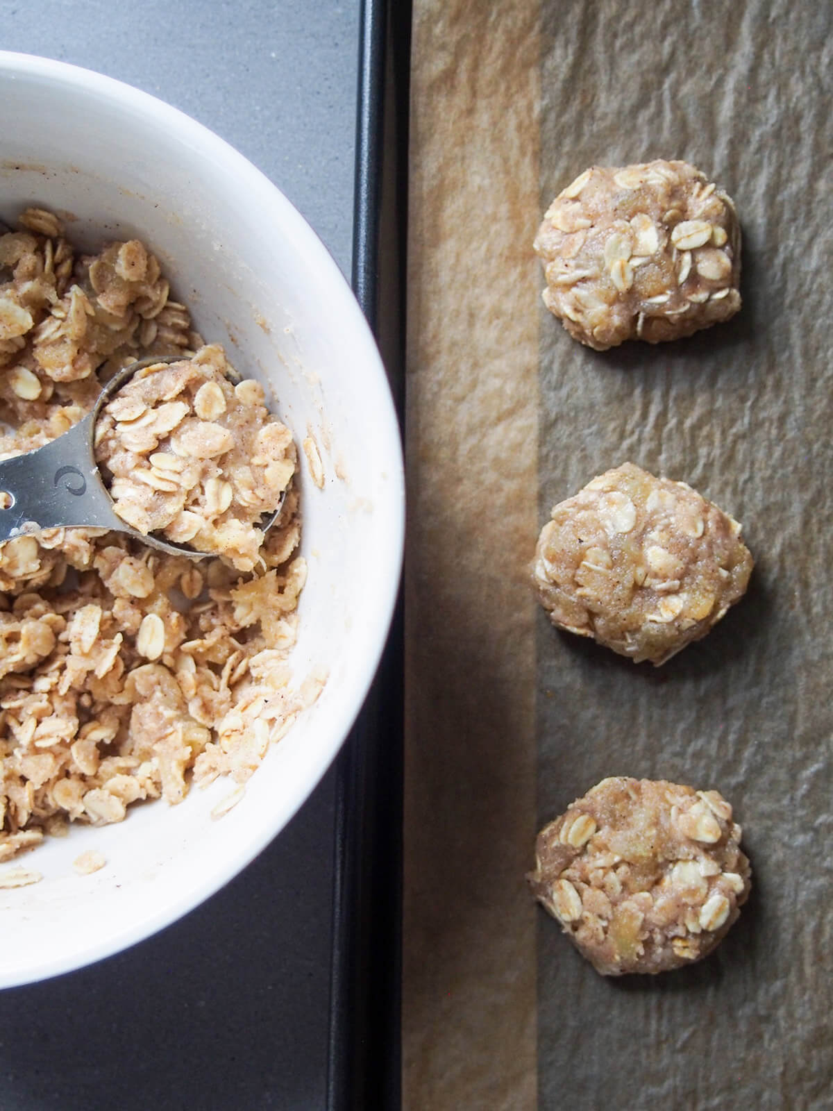 forming spiced maple oatmeal cookies forming cookies with spoon and some on lined baking sheet to side