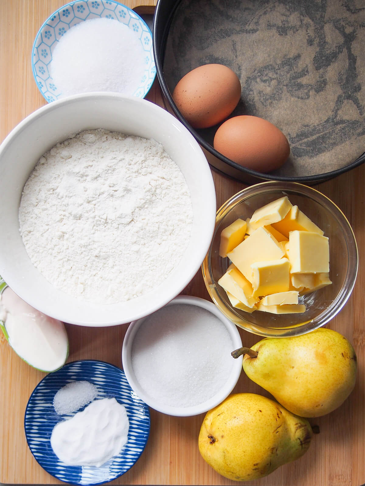 bowls with flour, butter, sugar and creme fraiche with eggs and butter to side