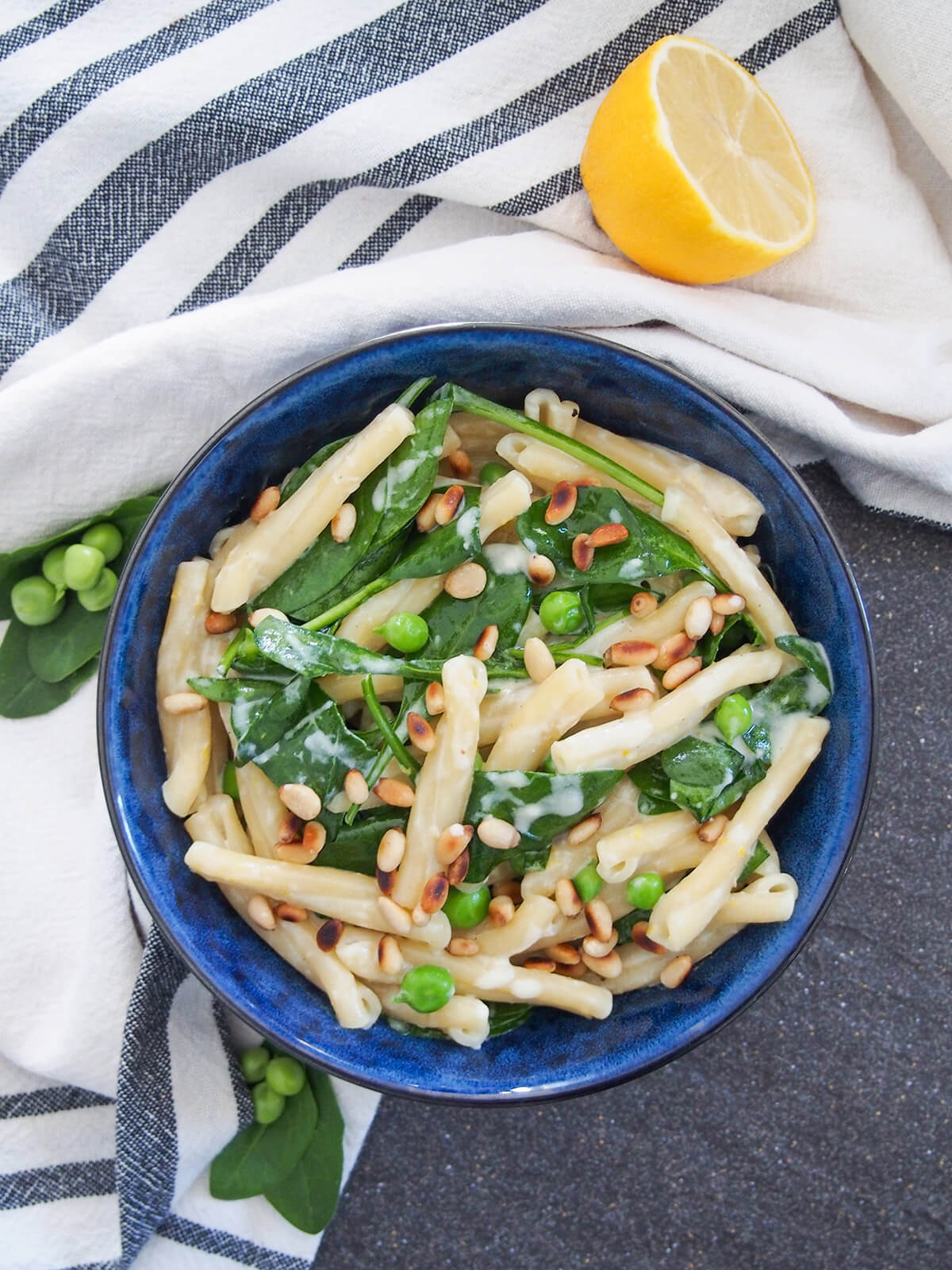 bowl of lemon mascarpone pasta from overhead with half lemon above bowl
