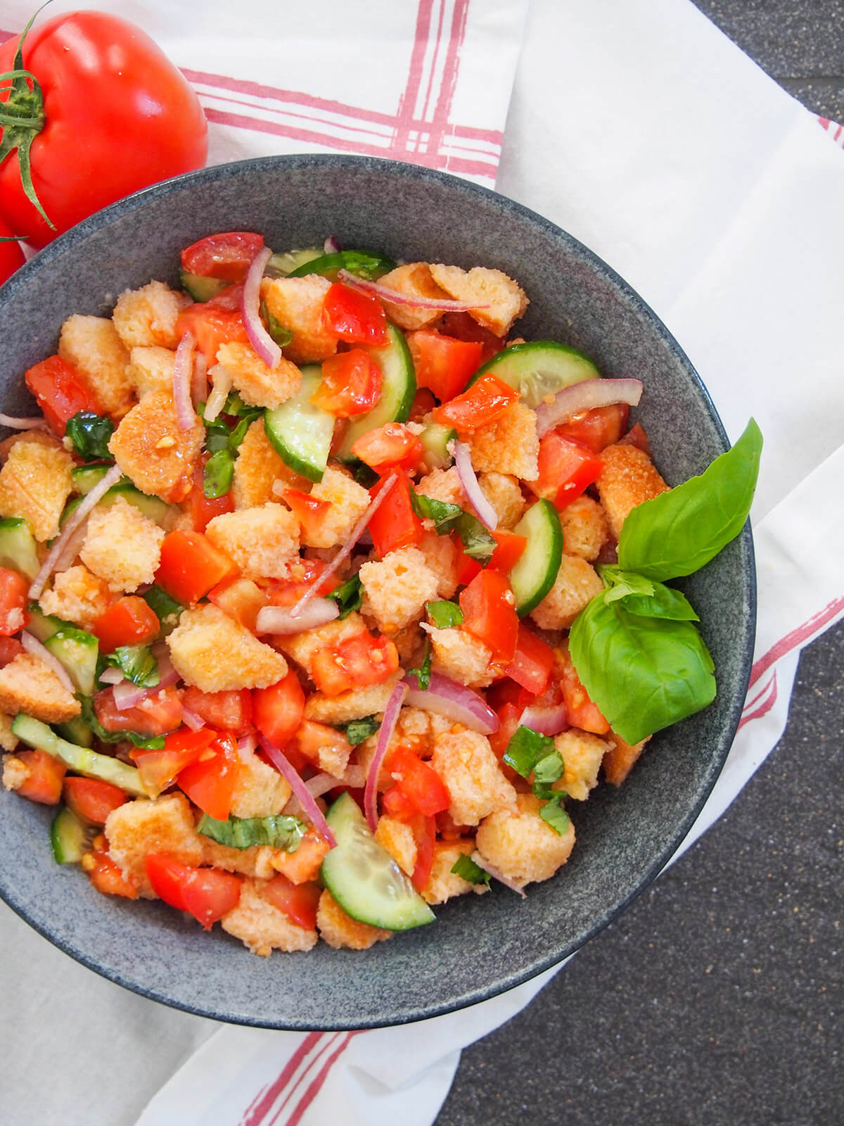 panzanella salad with basil garnish on side of bowl