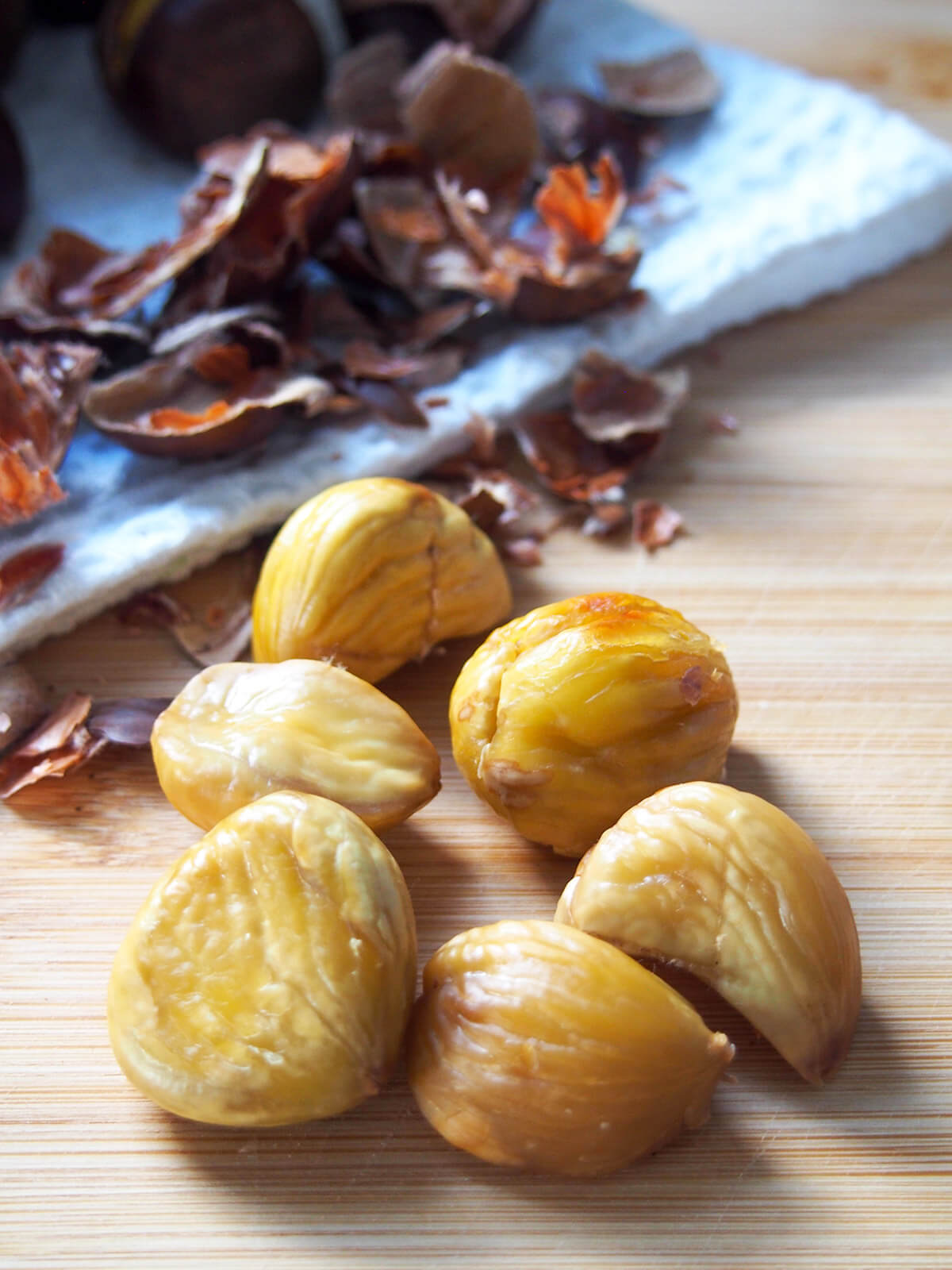 peeling chestnuts with shells on cloth behind