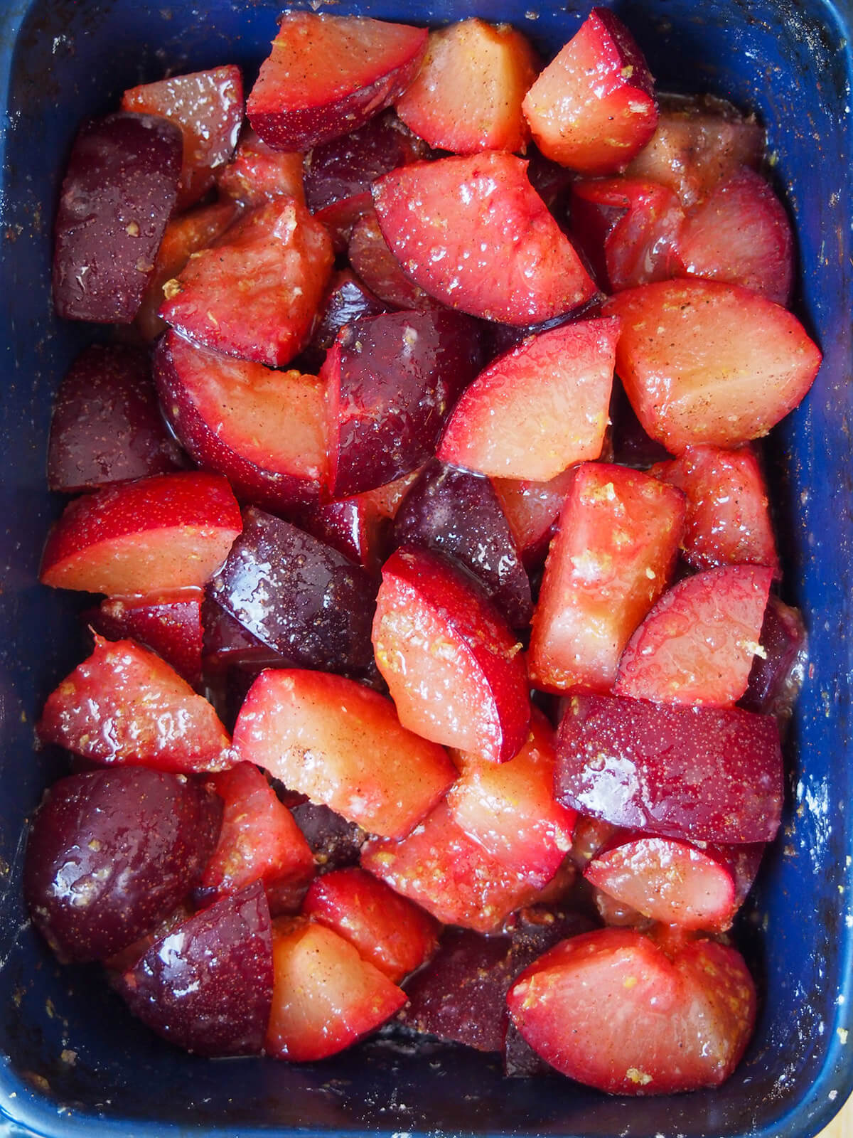 plums tossed with lemon and sugar in baking dish