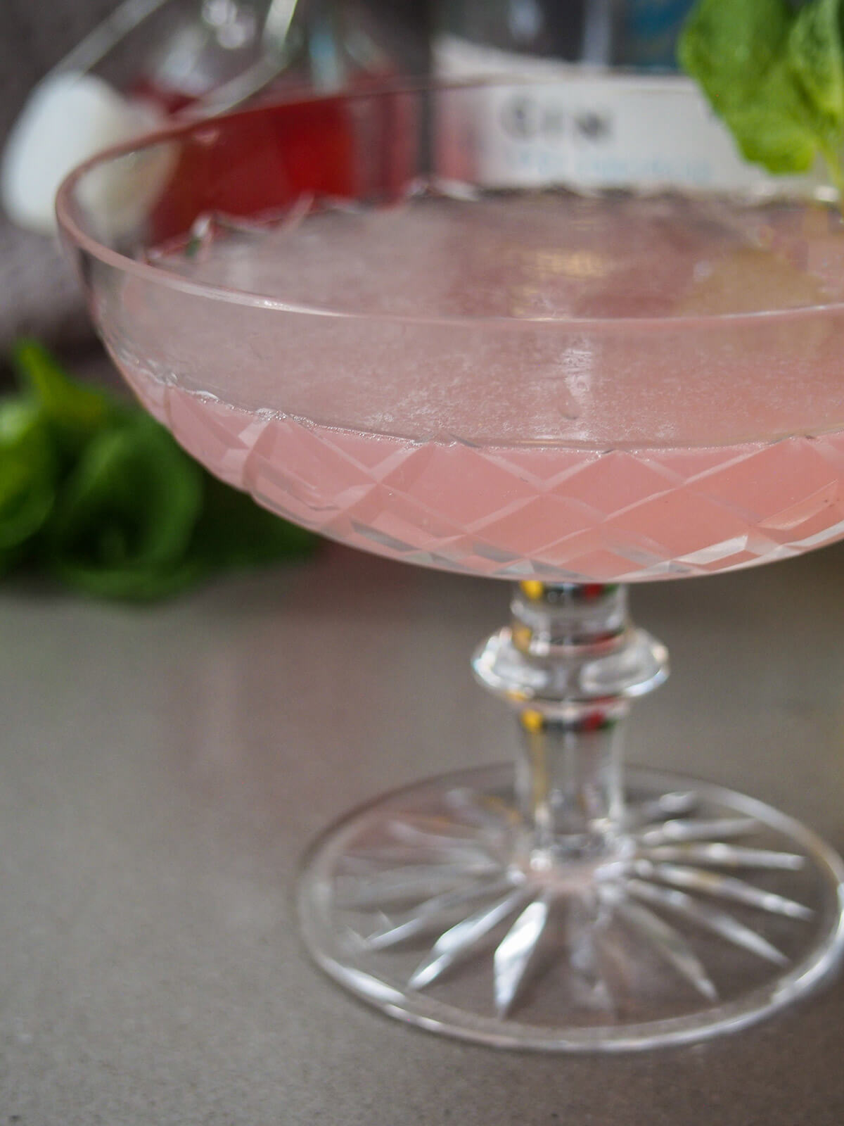 side view of glass with pink cocktail in it