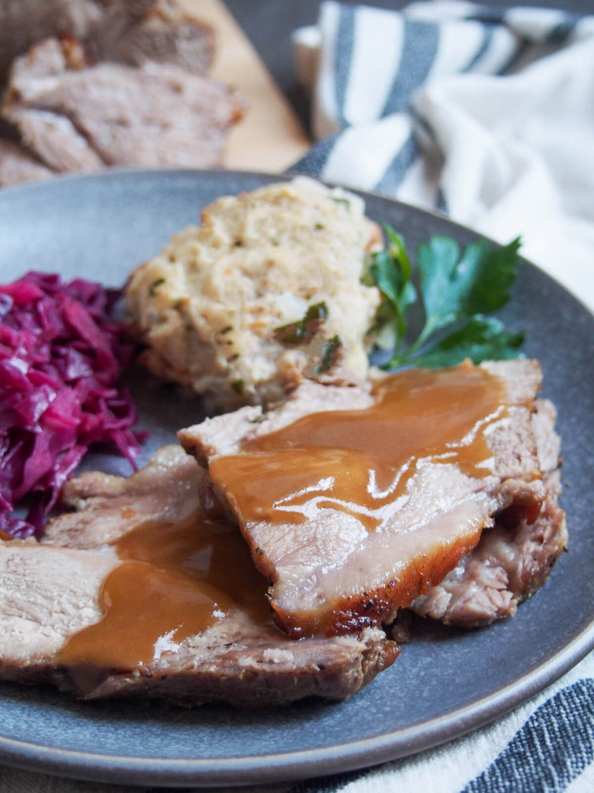 close up of slices of Schweinebraten - German pork roast - topped with gravy