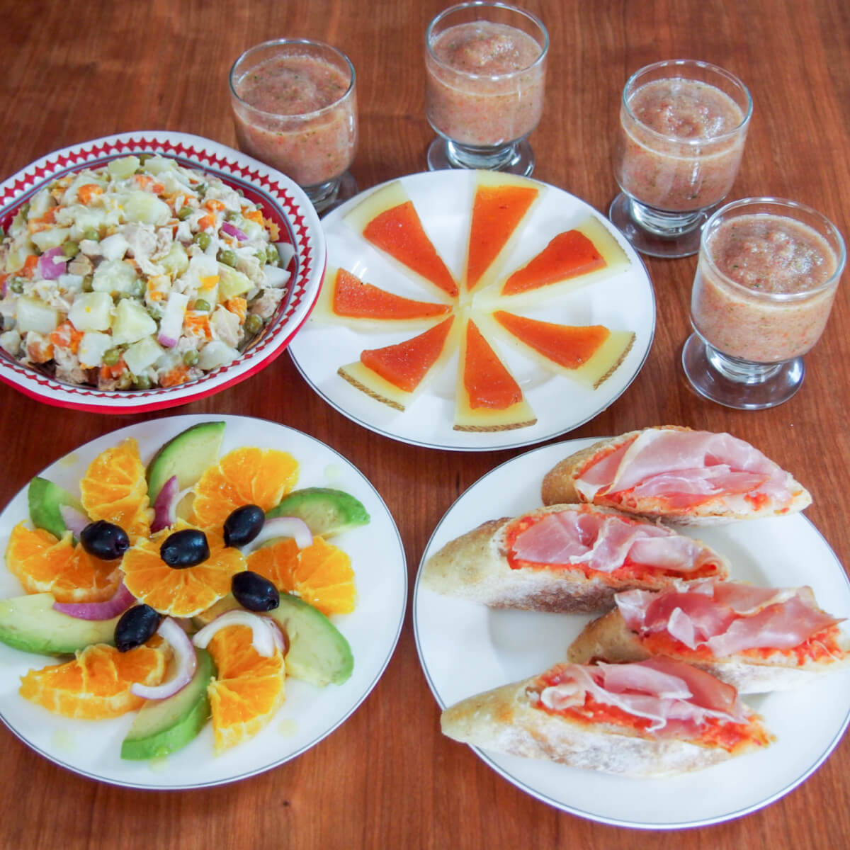 simple summer Spanish tapas on plates with glasses of gazpacho to side