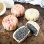 Chinese snow skin mooncakes with one cut open in front showing filling