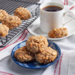 plate of spiced maple oatmeal cookies in front of coffee cup