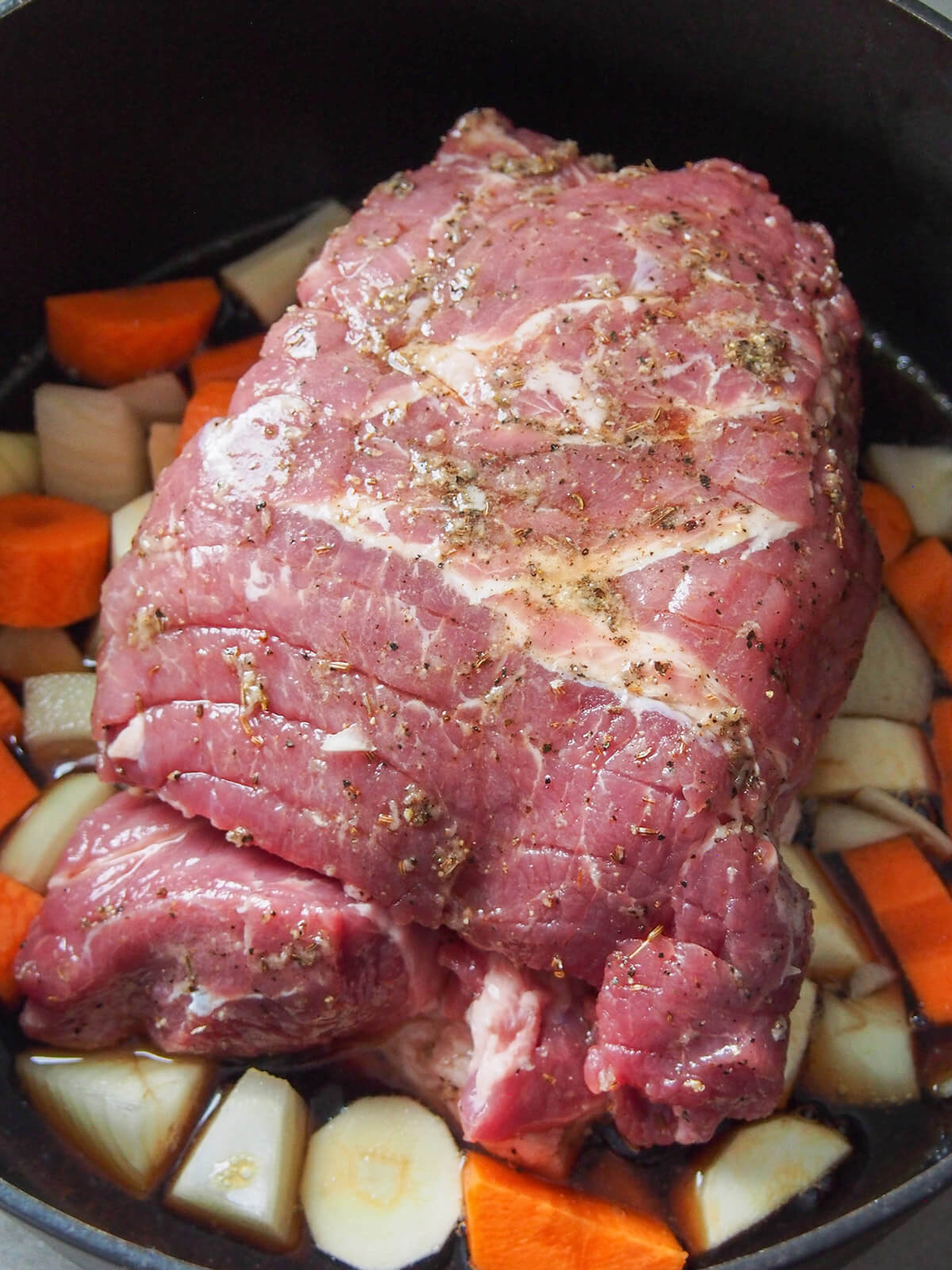 pork in pot with vegetables around ready to cook