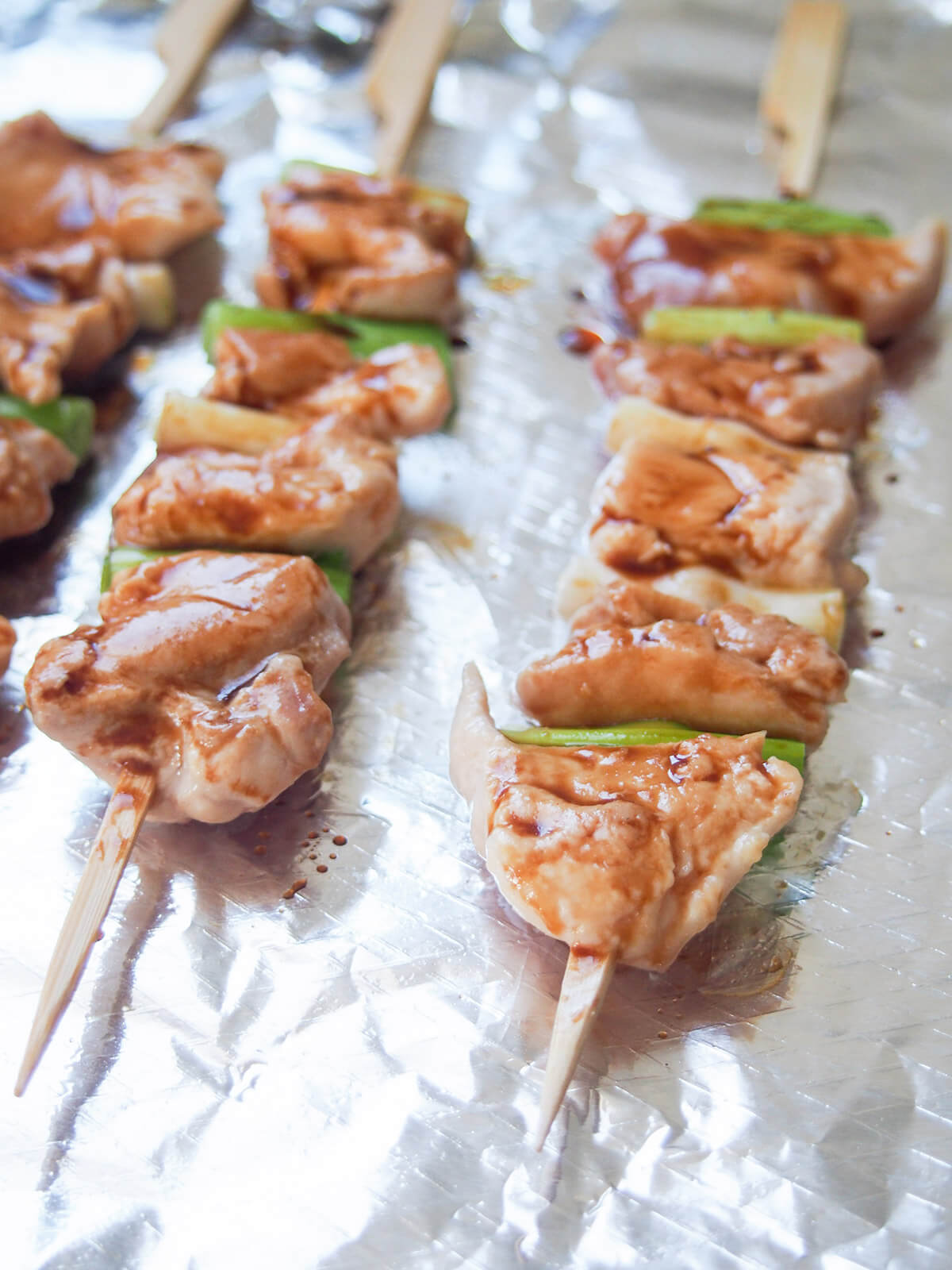 basting chicken skewers during cooking