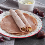 two rolled up chestnut crepes on top of more on plate