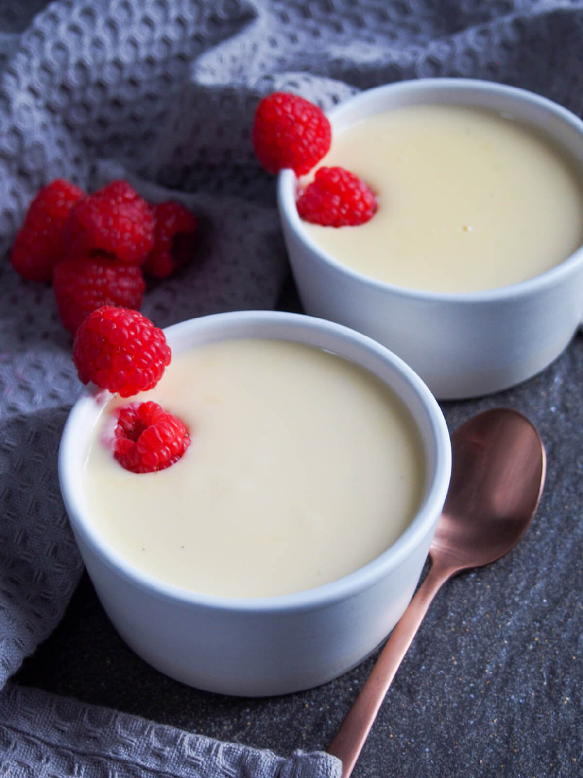 bowl of creme Anglaise with spoon to side and another bowl behind