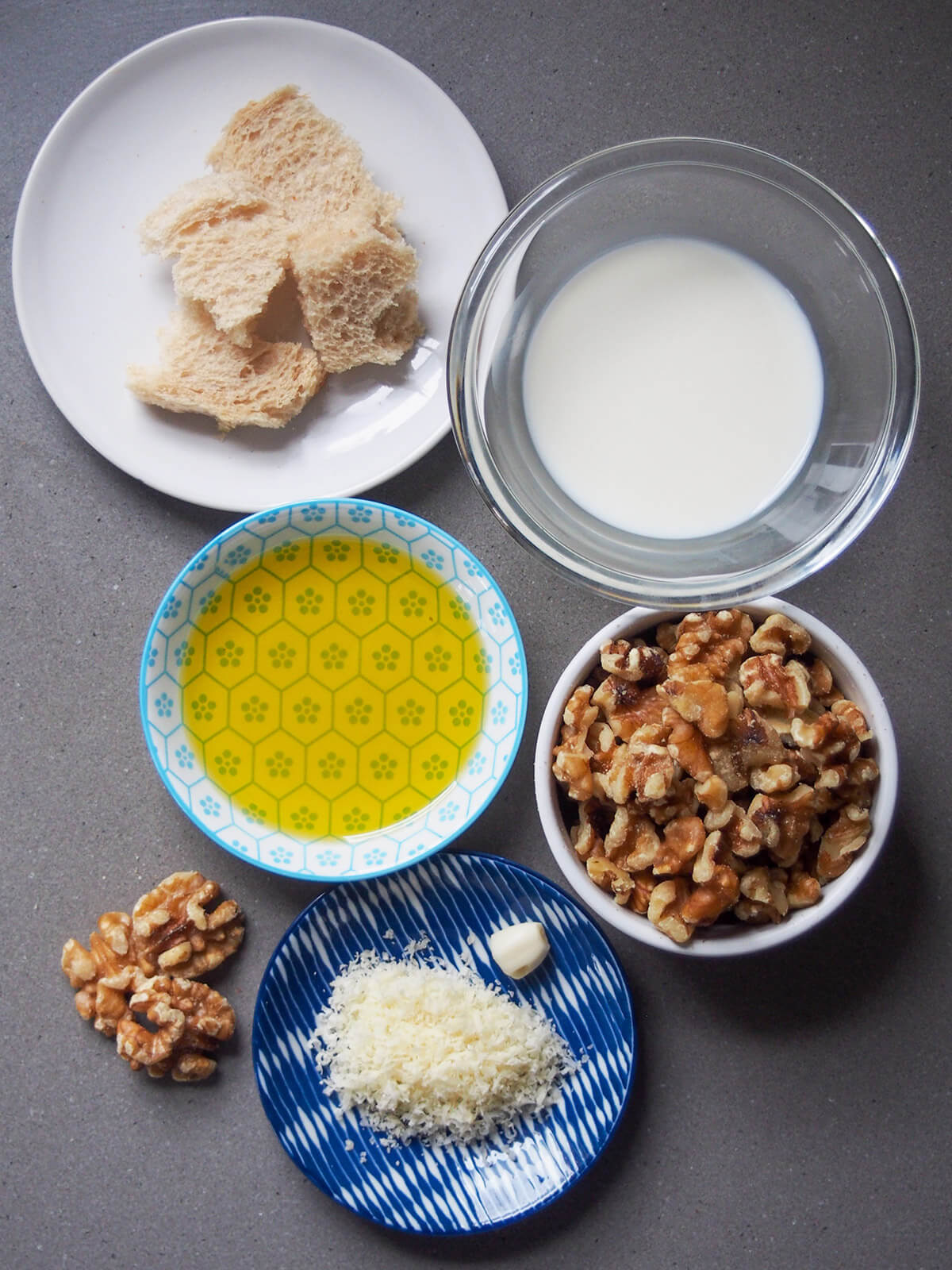 bowls with milk, bread, walnuts, olive oil and cheese
