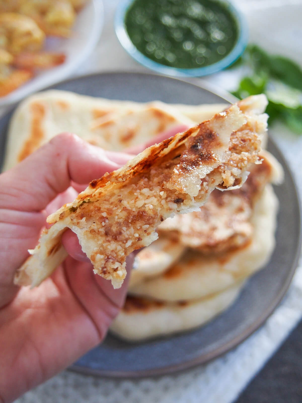holding part of a naan in hand showing filling inside