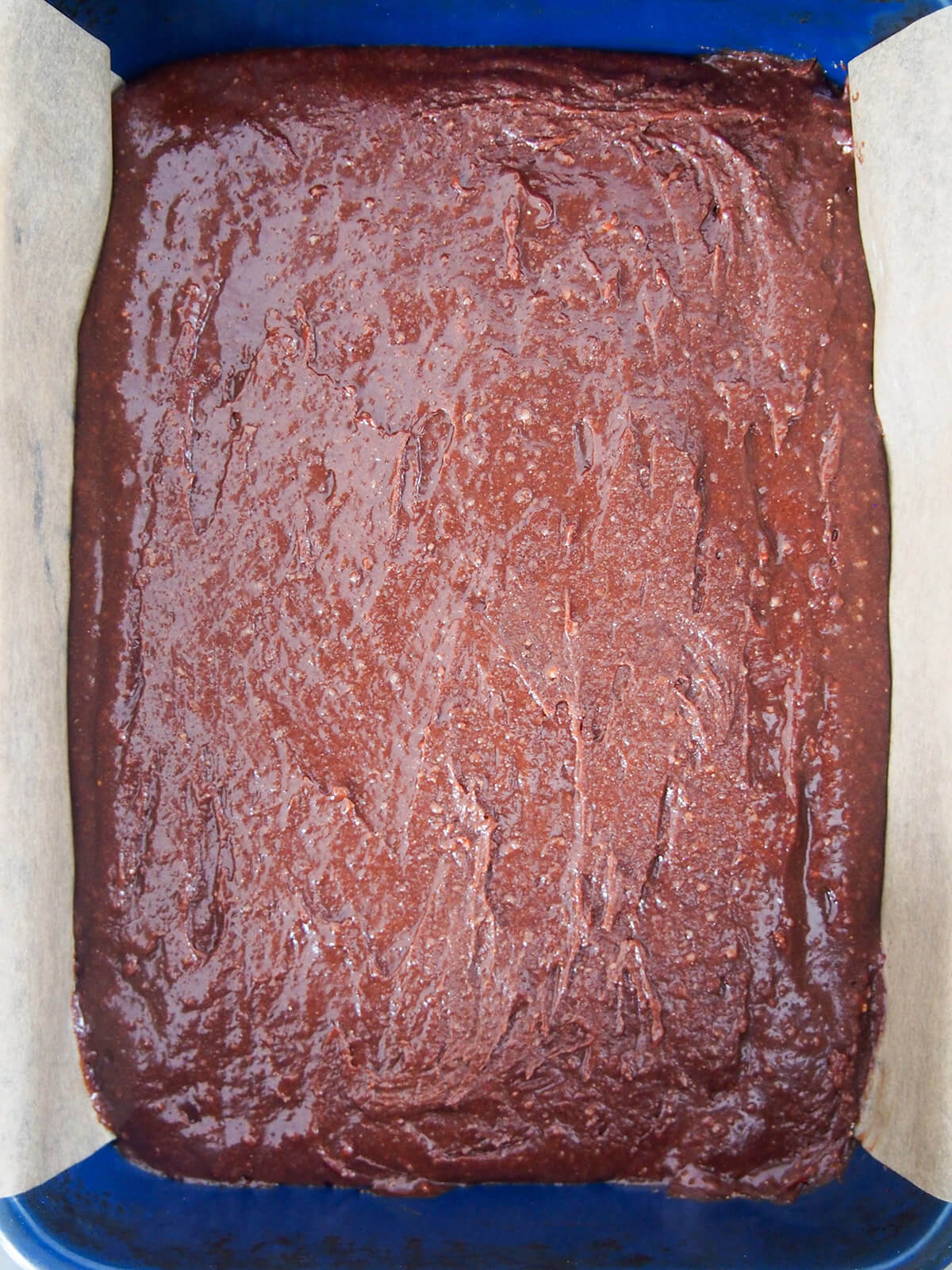 brownie batter in lined dish before baking