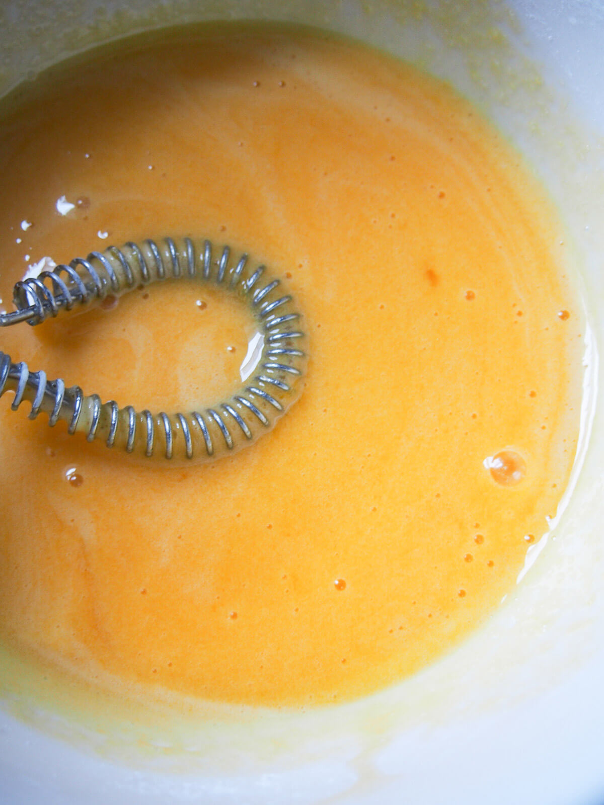 bowl with egg yolk and sugar mixture and whisk to side