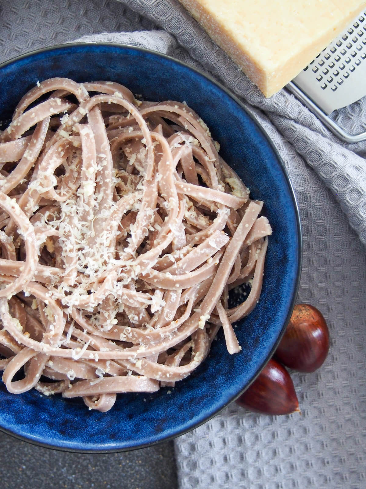 This chestnut pasta is a wonderfully tasty homemade pasta with a gently sweet, nutty flavor. It's easy to make and cooks up in no time. It pairs perfectly with simple sauces for comfort food deliciousness. partial view of bowl of chestnut pasta from overhead.
