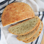 cut loaf of no knead olive oil rosemary bread from overhead with slices to bottom