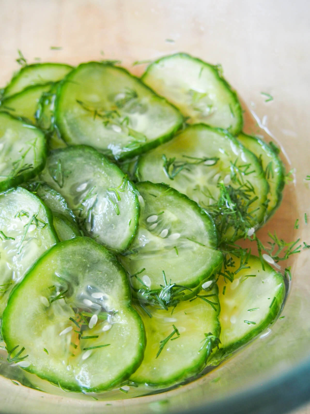 adding pickling liquid over pressed cucumber slices