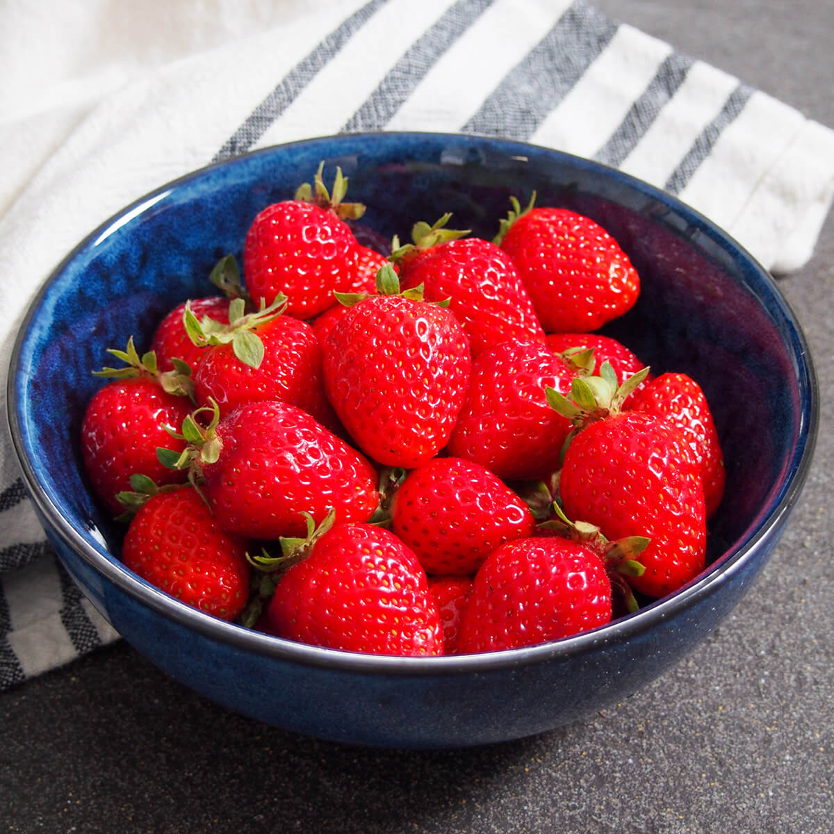 blue bowl filled with strawberries