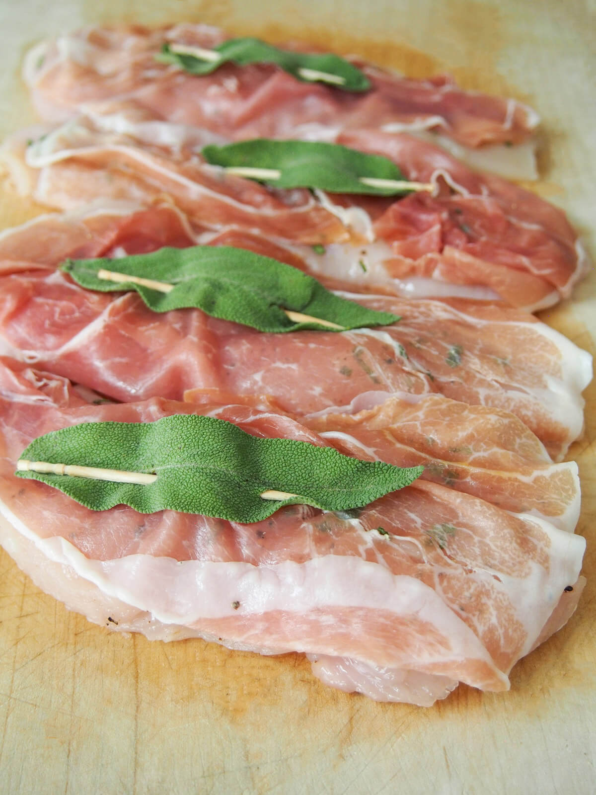 chicken topped with prosciutto and sage before cooking