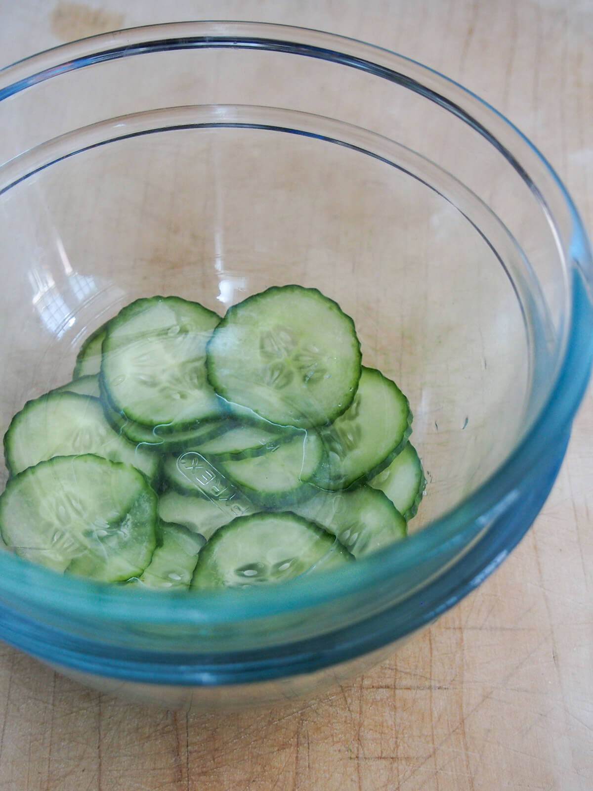 pressing slices of cucumber between bowls