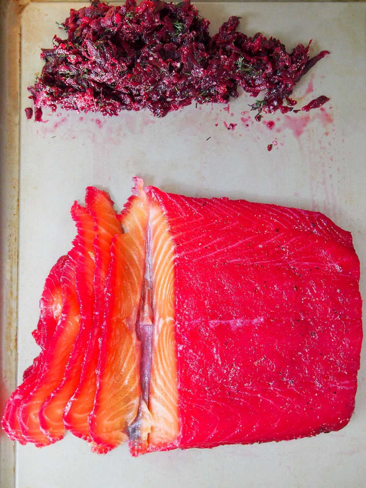 slicing beet cured salmon slicing salmon which has pink tinge on top from beet cure