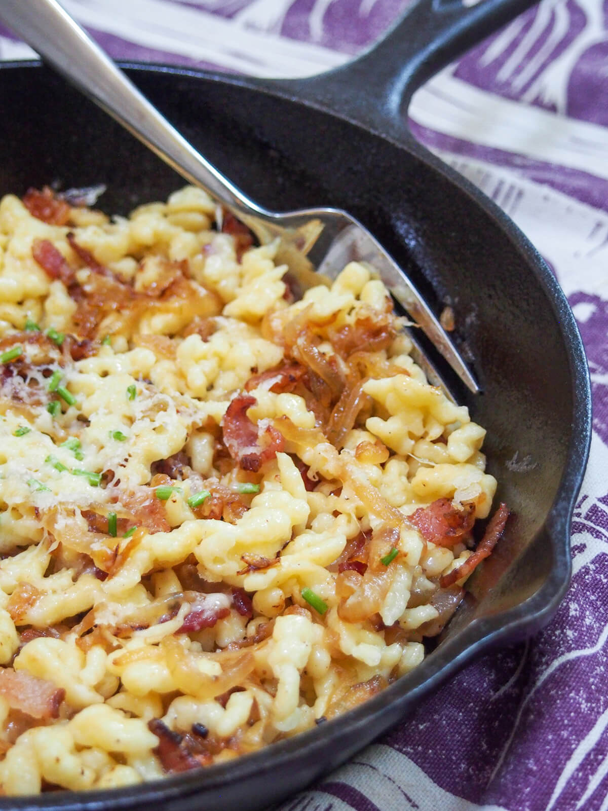 skillet of bacon onion spaetzle with fork at back