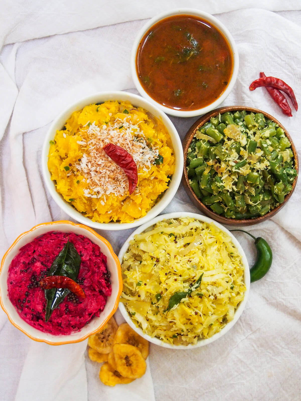 sadya dishes pumpkin erissery, thorans and beet pachadi with rasan from overhead