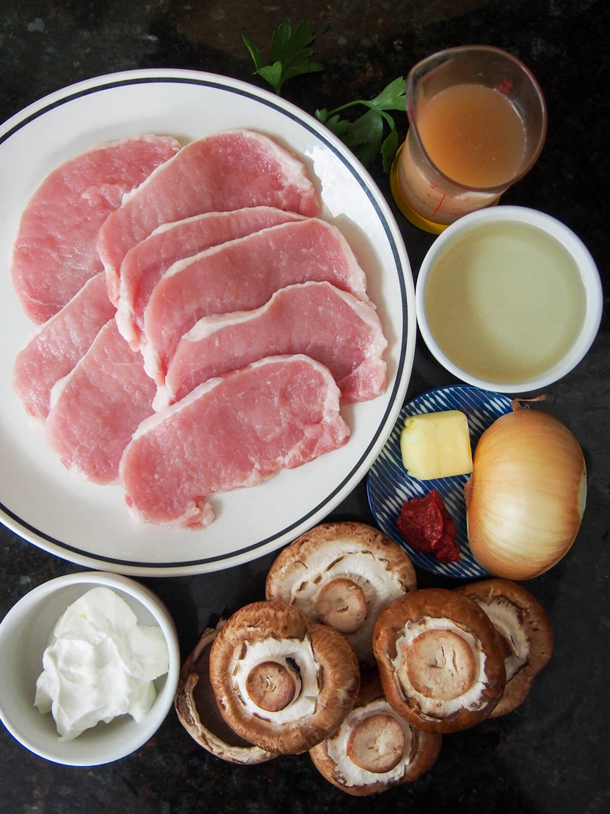 pork, mushrooms, cream, wine and stock in dishes next to each other