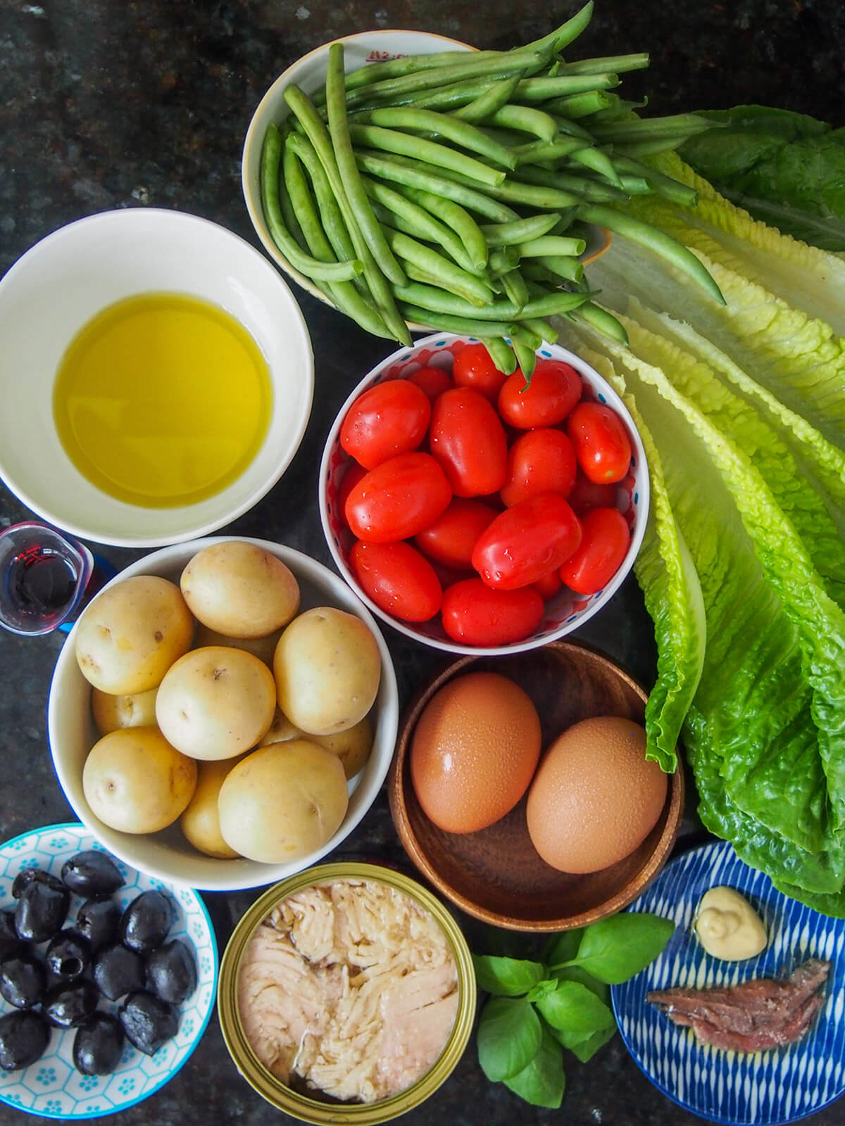bowls with potatoes, beans, tomato, egg, olives and tuna