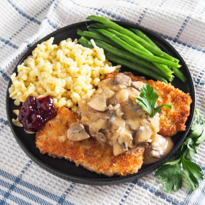 plate of jaegerschnitzel with beans and spaetzle