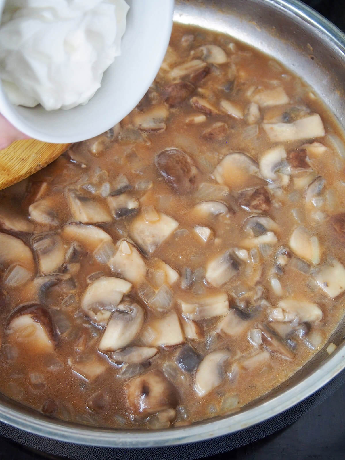 adding cream to mushroom sauce