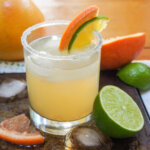glass of paloma cocktail with half lime to side
