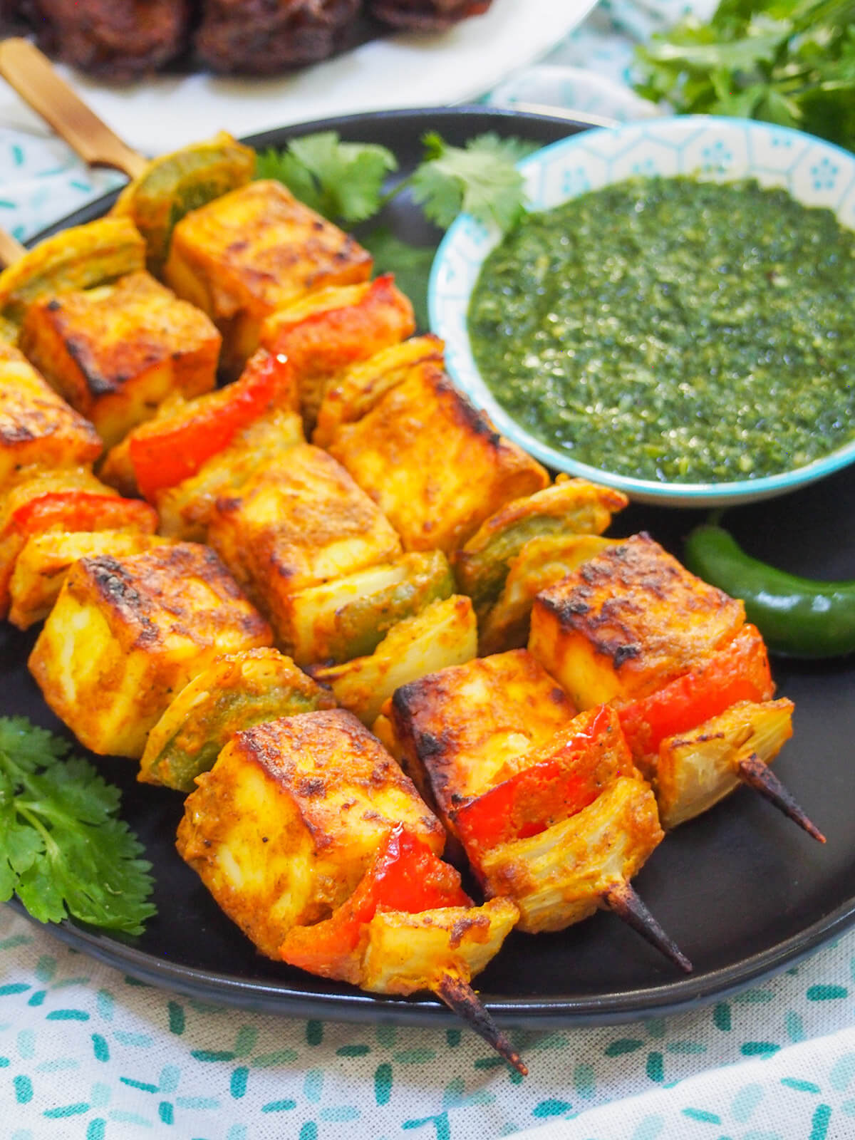 Paneer tikka are a bright and tasty vegetarian appetizer or snack, combining chunks of mild cheese and vegetables with a spiced marinade. They're really easy to make and perfect for entertaining or any excuse. paneer tikka skewers close up