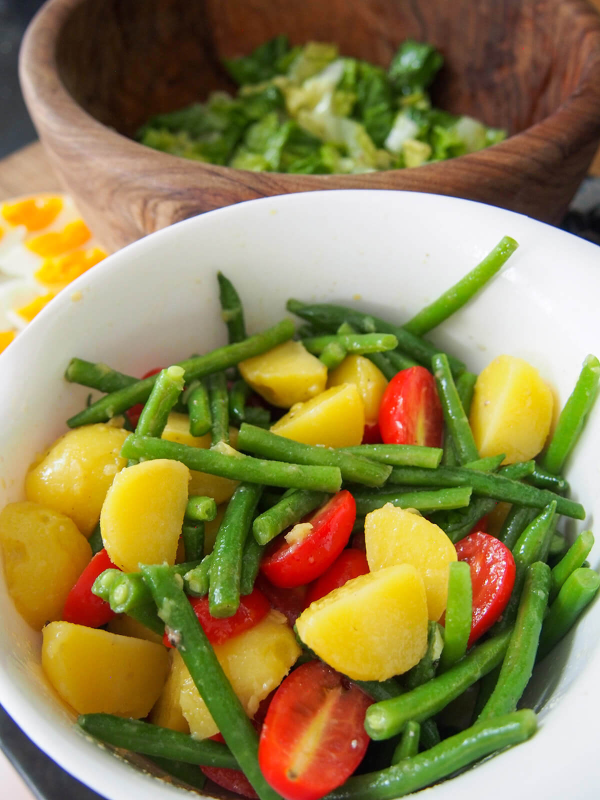 bowl of beans, tomato and potato with lettuce behind