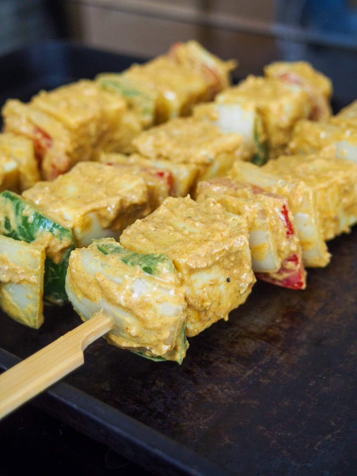 skewers ready to cook skewers resting on edge of baking sheet