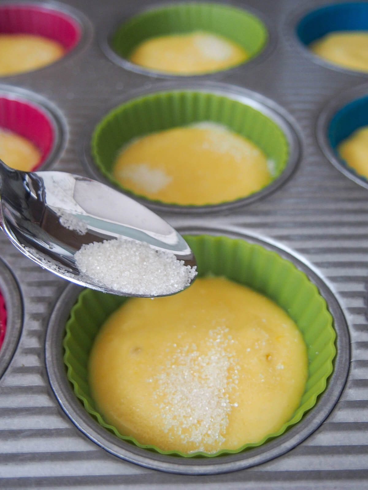 sprinkling sugar on muffin mixture in casing