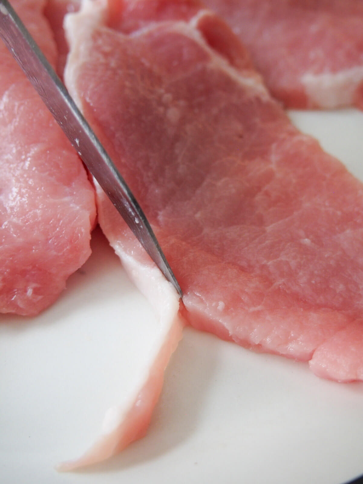 trimming fat from pork cutlets