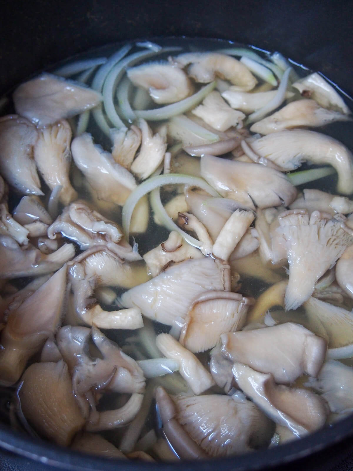 adding mushrooms and onion to broth