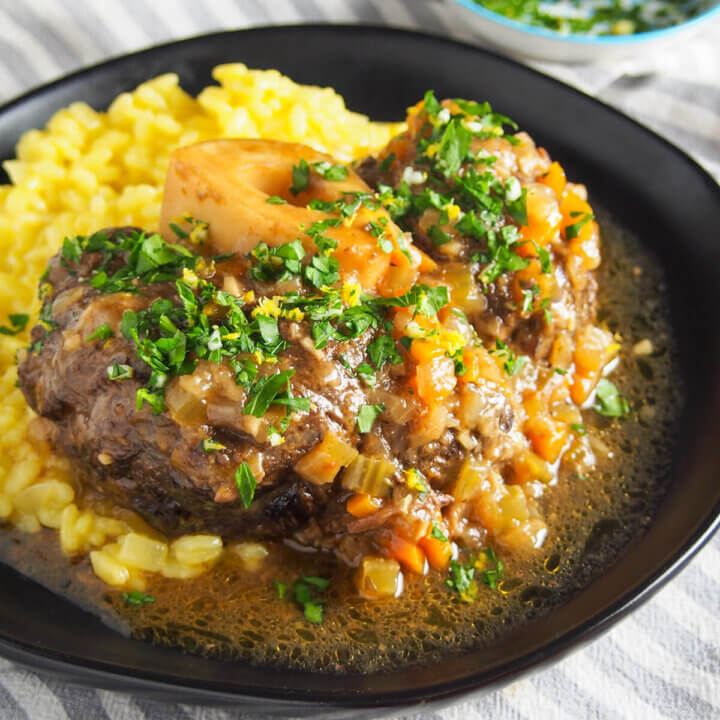 close up of beef osso bucco on plate with risotto