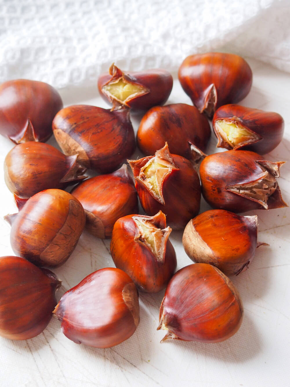 boiled chestnuts slightly burst open at one end on board