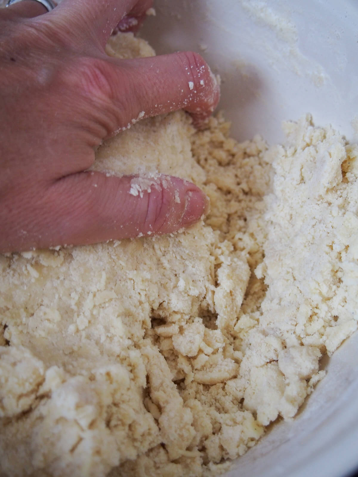 making vanillekipferl dough pressing together cookie dough with hand