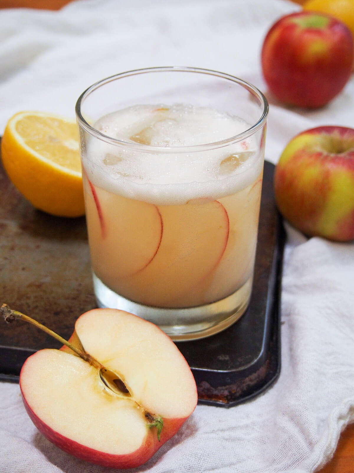 calvados sour with foamed top, cut apple in front of glass