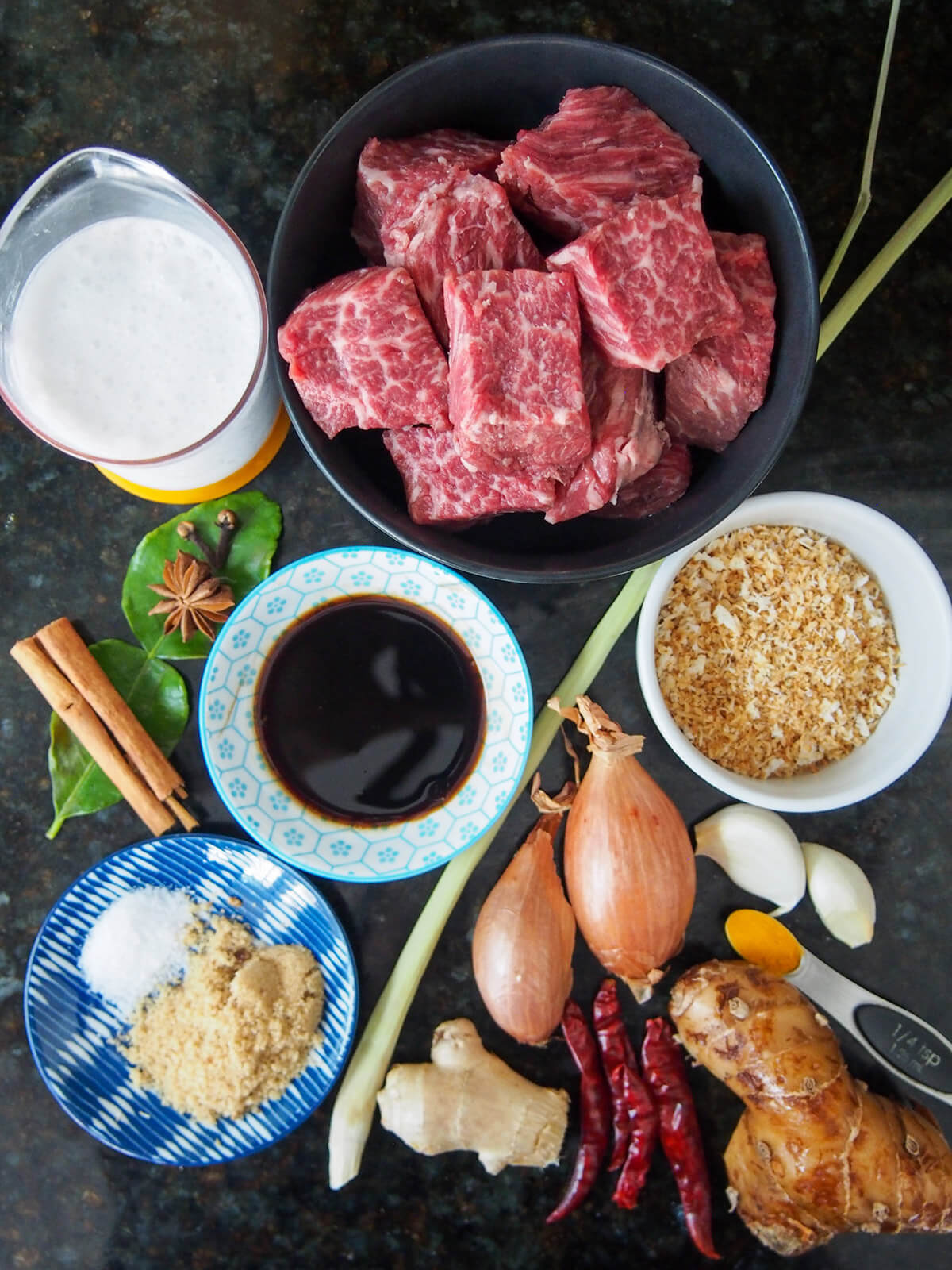 bowl of diced beef, dishes with coconut, tamarind, coconut milkm shallots, ginger, chili, sugar and spices