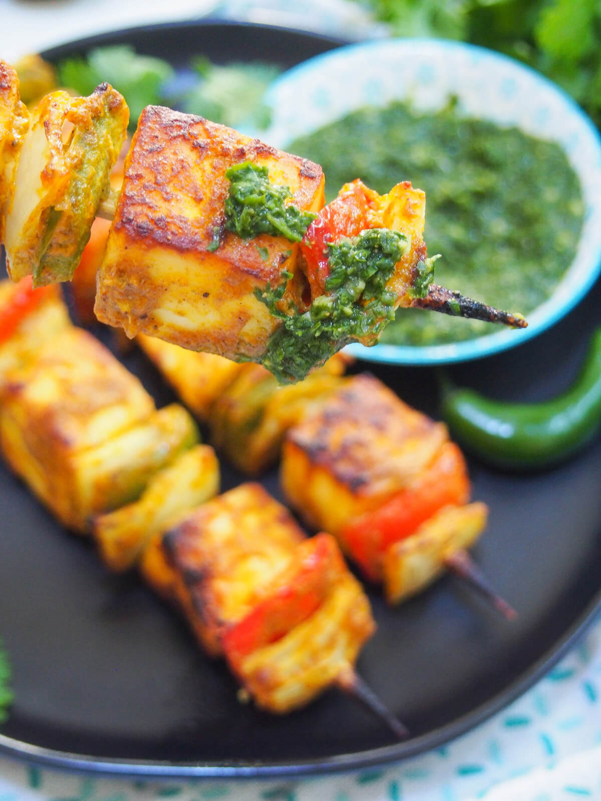 piece of paneer tikka with chutney on it paneer tikka skewer with chutney on it
