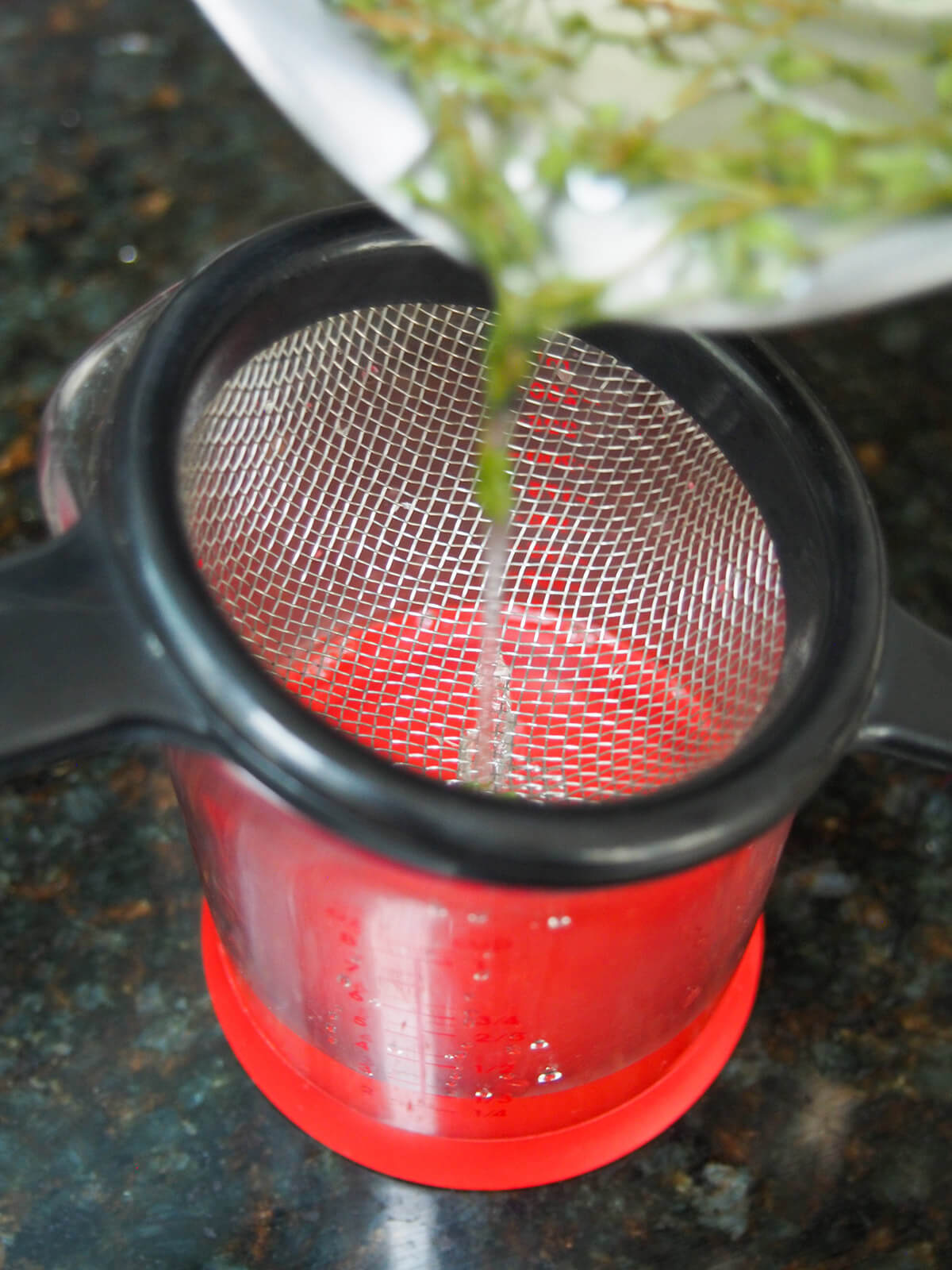 pouring syrup through strainer into pourer