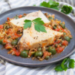 Sicilian swordfish with olives and capers with parsley to side of plate
