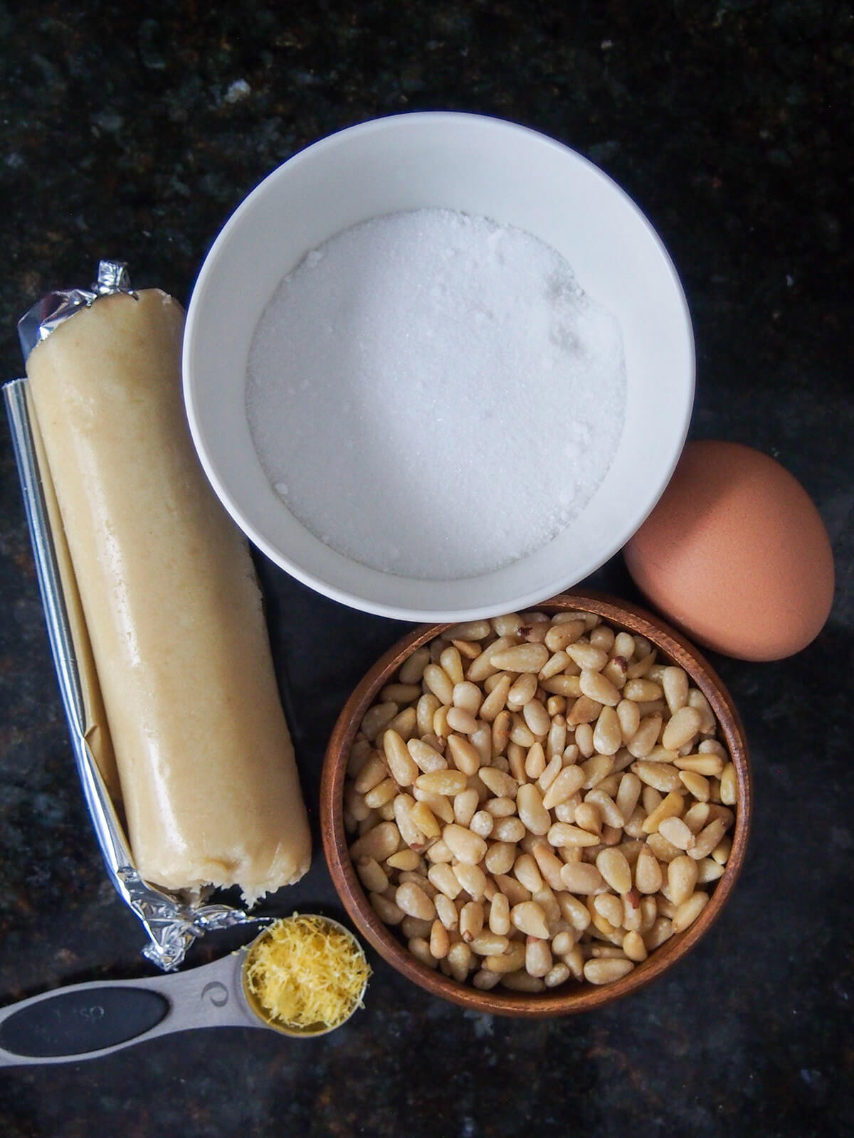 almond paste, egg, bowls with pine nuts and sugar